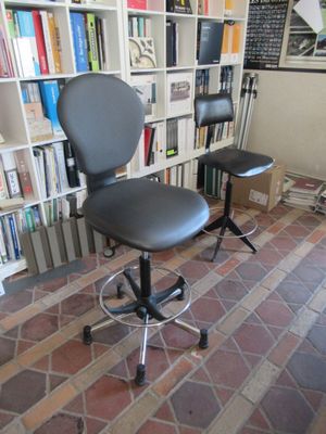 une chaise de bureau noire placée devant une bibliothèque