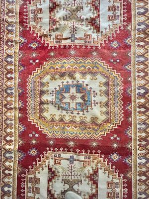 a red and white rug with a design on it