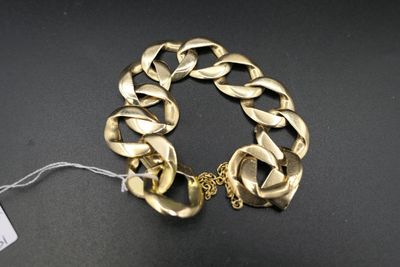 gros plan d'un bracelet en chaîne en or sur une surface noire