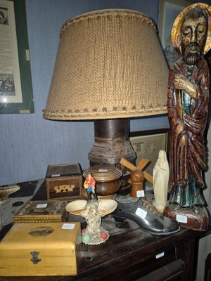 a table with a lamp, a book, and a statue on it