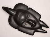a black sculpture of a man ' s face on a white surface