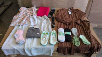 Plusieurs paires de chaussures et plusieurs vêtements sont disposés sur une table en bois