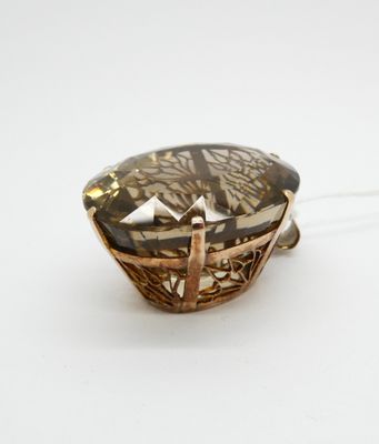une image représentant un pendentif orné d'une grosse pierre facettée sertie dans un cadre en forme de panier
