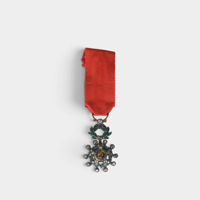 gros plan d'une médaille sur une surface blanche avec un ruban rouge
