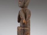 a wooden statue of a man holding a piece of wood