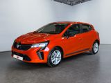 Une voiture rouge est garée dans une pièce aux murs blancs.