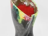 a black vase with a red and green design on it