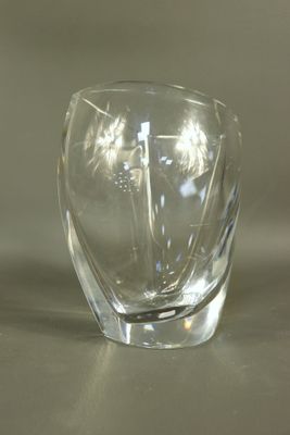 un vase en verre transparent posé sur une table, sur fond blanc