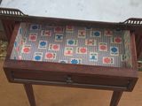 a small table with a marble top and a drawer with a drawer underneath it