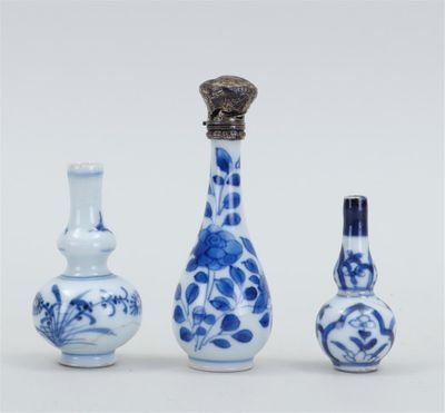 trois vases bleus et blancs sont posés les uns à côté des autres sur une surface blanche