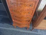 a wooden chest of drawers next to a door