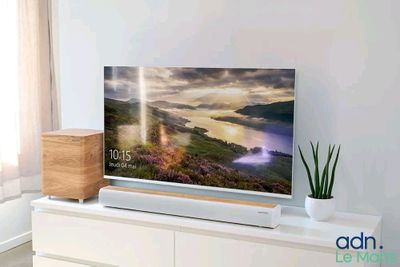 une télévision à écran plat posée sur une commode blanche