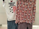 two shirts that are on a rack in front of a box