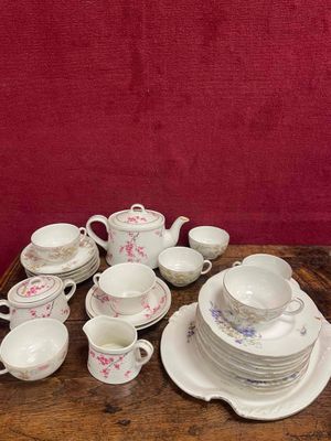 une table en bois sur laquelle sont posés tout un tas d'assiettes et de tasses
