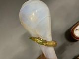 a glass spoon with a worm inside of it on a table