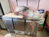 Plusieurs sacs de provisions sont posés sur le plan de travail d'une cuisine
