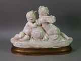 a figurine of a boy and a girl laying on the ground