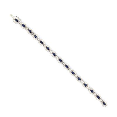 un gros plan d'un bracelet orné de pierres bleues sur fond blanc