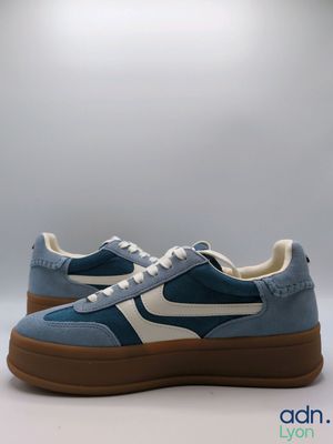 un gros plan sur une paire de baskets bleues et blanches