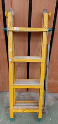 une échelle jaune appuyée contre un mur en bois