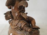 an antique bronze statue of an angel holding a bird on a pedestal