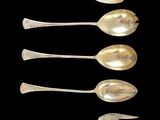 several spoons and forks are arranged in a row on a black background
