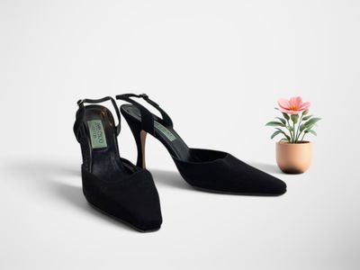 une paire de chaussures à talons hauts noires à côté d'une plante en pot