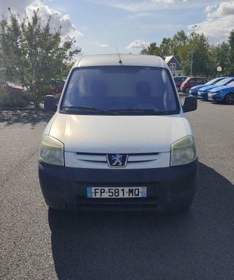 une petite camionnette blanche garée dans un parking