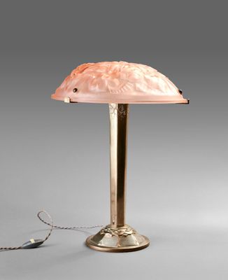 une lampe avec un abat-jour rose posée sur une table