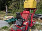 a red lawn mower that is parked in the grass