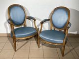 two blue chairs sitting next to each other on a tiled floor