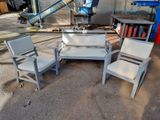three chairs and a table in front of a building
