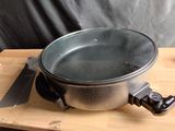 a pan on a wooden table with a knife