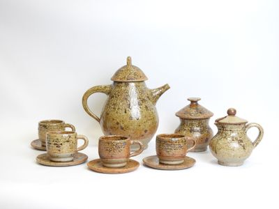 a group of tea pots and cups sitting on a table