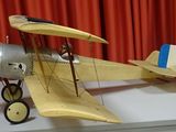 a model of a plane on a table with a red curtain in the background