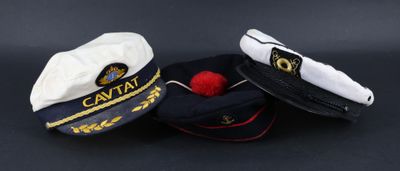trois bonnets surmontés d'un pompon rouge