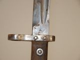 a close up of a knife on a wooden pole