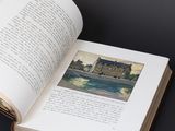 an open book with a picture of a castle on it