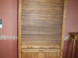 a wooden cabinet in the corner of a room