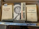 many books in a box on a table