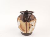 a brown and white vase sitting on a white surface