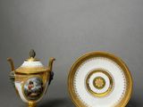 two pieces of porcelain and gold on a gray surface