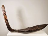 a wooden sculpture of a fish on a white pedestal