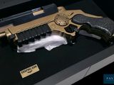 a gold and black gun on display in a case