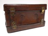 a brown leather suitcase sitting on top of a white table