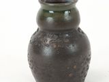 a brown vase that is sitting on a white surface