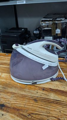 a white and purple iron on a wooden table