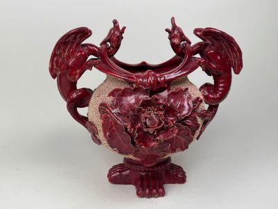 a red vase with a dragon decoration on it