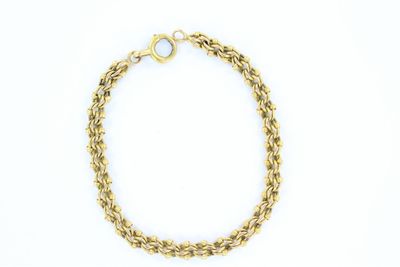 gros plan d'un bracelet en chaîne en or sur fond blanc