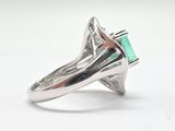 a close up of a ring with a green stone in it